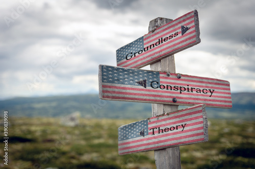 groundless conspiracy theory text on wooden signpost outdoors with the american flag to simulate the 2020 presidential election. © Jon Anders Wiken
