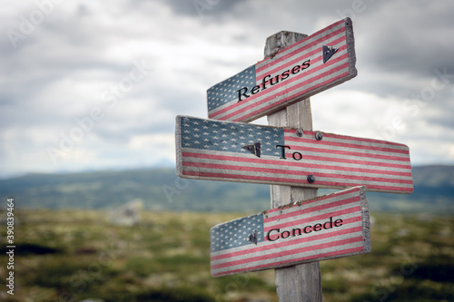 refuses to concede text on wooden signpost outdoors with the american flag to simulate the 2020 presidential election.