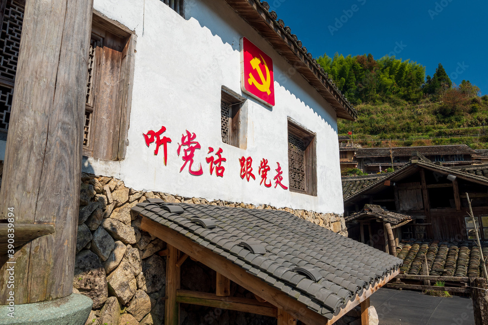 The Chinese Communist Party banner on the outside of the house. The text on the wall means 
