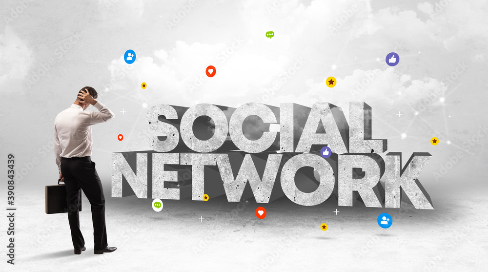 Young businessman standing in front of SOCIAL NETWORK inscription, social media concept Young businessman standing in front of SOCIAL NETWORK inscription, social media concept