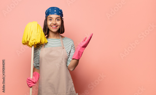 Fotografie young woman housekeeper feeling happy, surprised and cheerful, smiling with posi