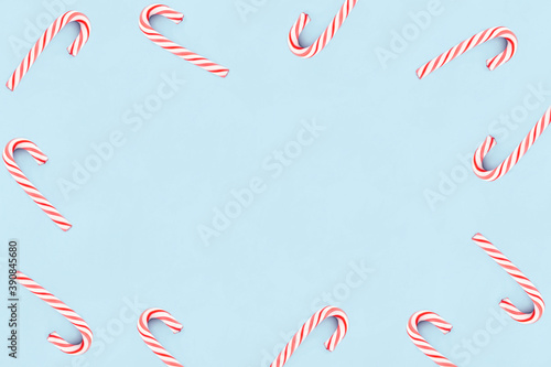 Christmas composition. Red and white candies on blue background. Christmas, winter, new year concept. Minimal style. Flat lay, top view, copy space.