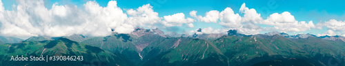 Panorama of the mountain range on the horizon. High peaks covered with clouds.