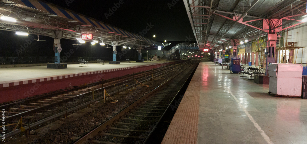 Empty railway platform at night with no people around.
