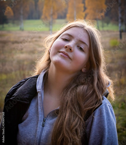 teenage girl with long blonde hair in autumn forest 