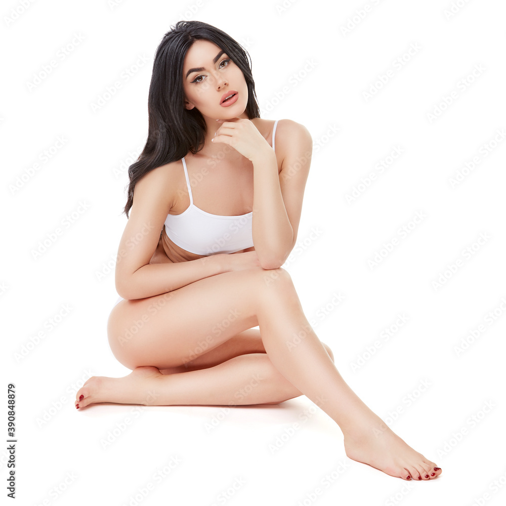 Fitness young woman with a beautiful body sitting on white background Fitness young woman with a beautiful body sitting on white background