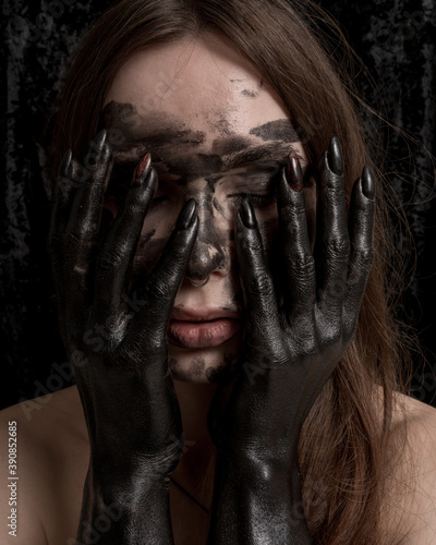 Female portrait with creative black colored scary hands