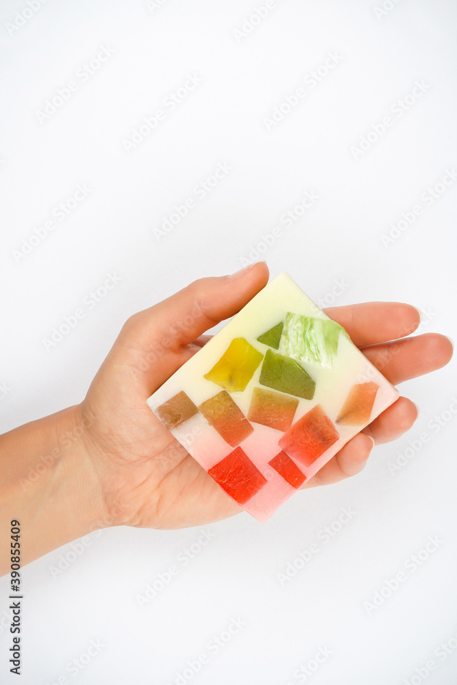 Soap with colorful pieces in hand, white background. Hygiene, disinfection, natural product concept. Top view, flat lay, copy space Soap with colorful pieces in hand, white background. Hygiene, disinfection, natural product concept. Top view, flat lay, copy space