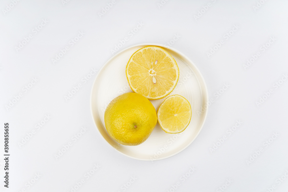 Lemon sliced on round plate, white background. Recipe, vitamin, immunity concept. Top view, flat lay, copy space. Lemon sliced on round plate, white background. Recipe, vitamin, immunity concept. Top view, flat lay, copy space.