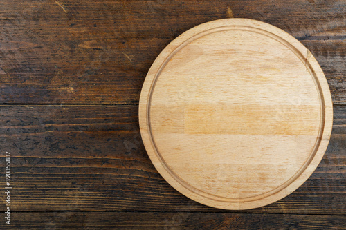 Round cutting board on a wooden table. Space for text.