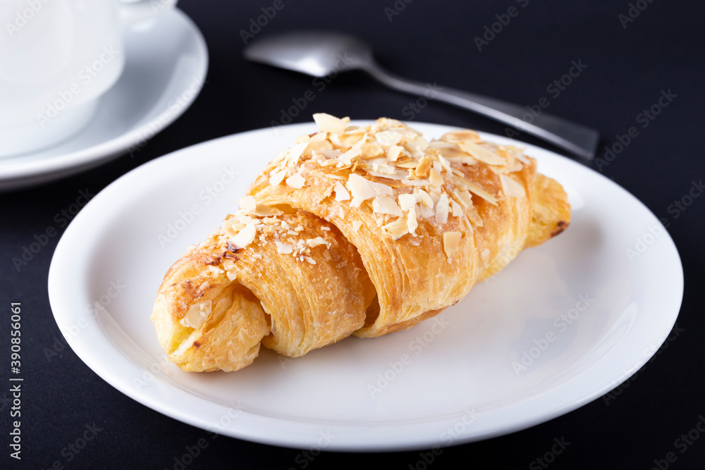 Croissant with almonds on a white plate. Croissant with almonds on a white plate.