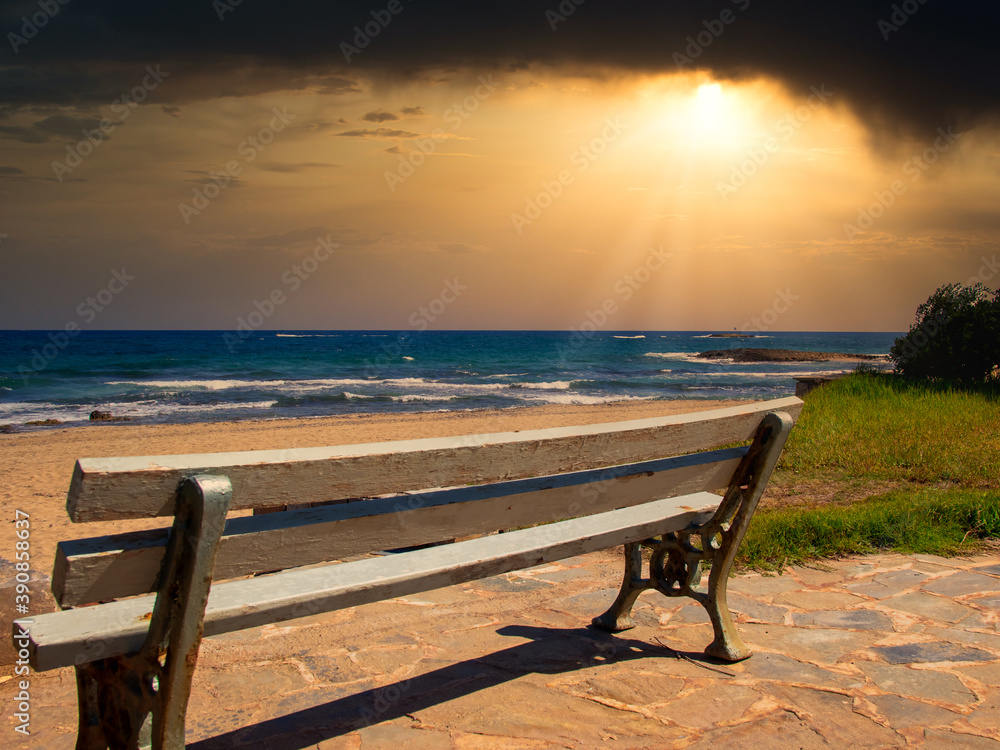 A lonely bench by the sea at sunset on the island Crete
