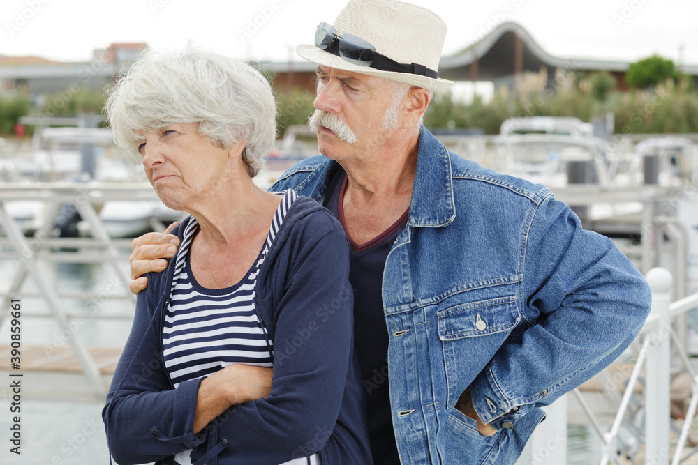 senior man trying to console grumpy wife