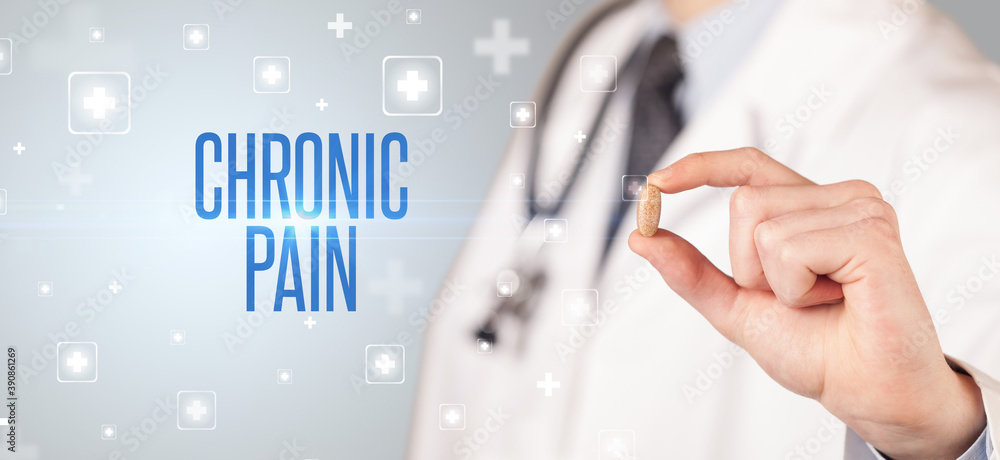 Close-up of a doctor giving a pill with CHRONIC PAIN inscription, medical concept Close-up of a doctor giving a pill with CHRONIC PAIN inscription, medical concept