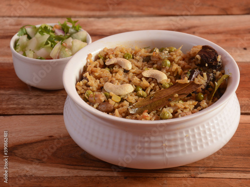 Traditional Vegetable / veg biryani made of seeraga samba rice with mixed veggies served with mixed raita, selective focus