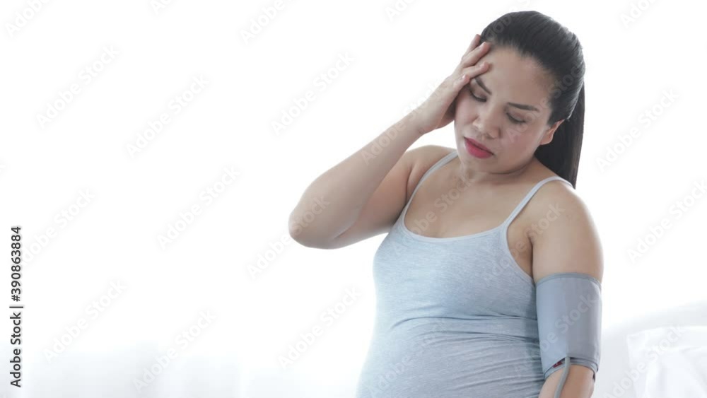 Young Asian pregnent mother got headache while sitting on bed Young Asian pregnent mother got headache while sitting on bed