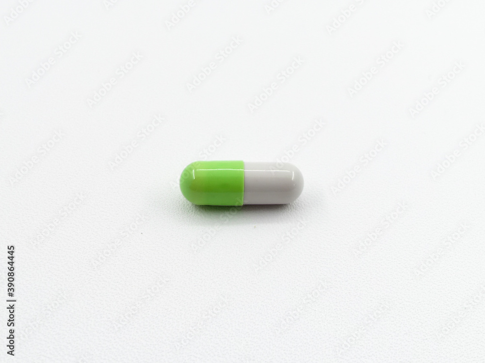 Close up of green and white pills capsule isolated on white background. Health care, medical, pharmacy concept Close up of green and white pills capsule isolated on white background. Health care, medical, pharmacy concept
