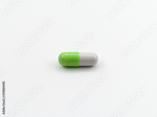 Close up of green and white pills capsule isolated on white background. Health care, medical, pharmacy concept
