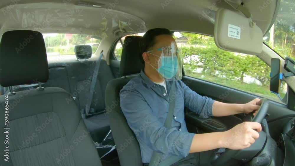 Indoor Shot Of A Vehicle With Plastic Barrier And Driver With Face Mask