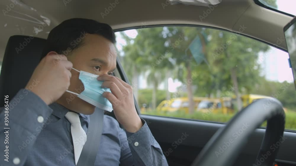 Business Man Wearing A Face Mask Inside His Car Before Driving Due To COVID-19 Pandemic