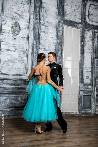 young couple in evening dance costumes dancing tango in the ballroom © константин константи