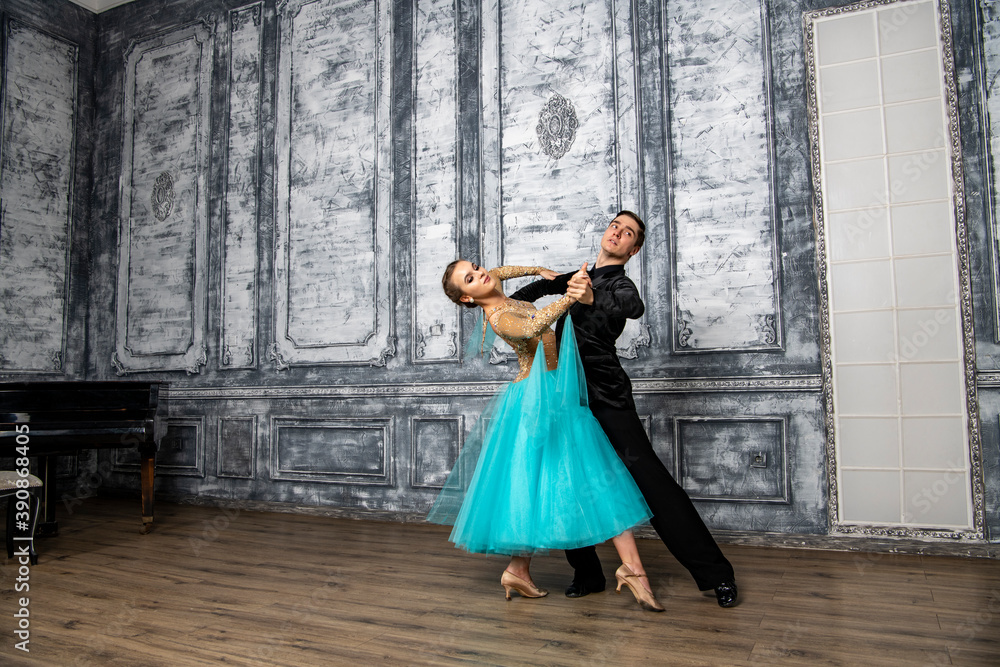 young couple in evening dance costumes dancing tango in the ballroom young couple in evening dance costumes dancing tango in the ballroom