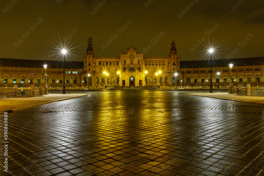 Plaza de España en Sevilla, Andalucía, foto nocturna con reflejo de luz en suelo y farolas con estrella de luz.