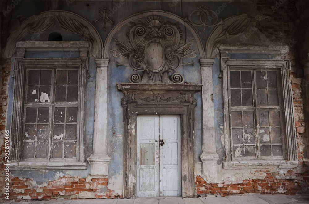 Old entrance doorway with emblem above on right side of ancient fortress castle in village of Pidhirtsi in Lviv region, Ukraine