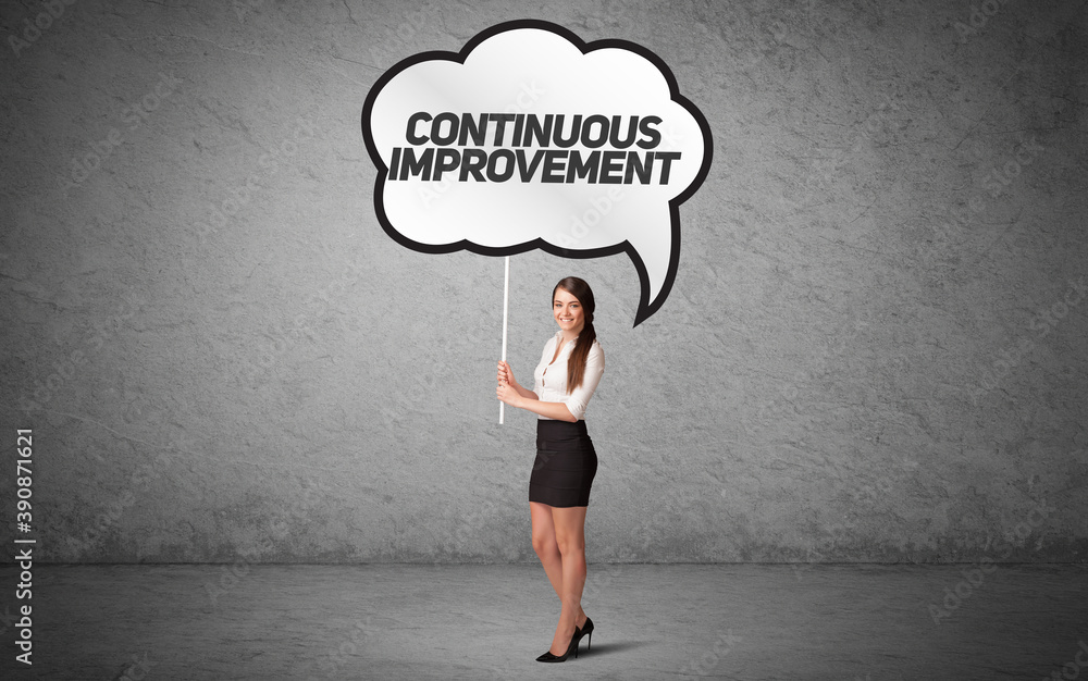 Young business person in casual holding road sign with CONTINUOUS IMPROVEMENT inscription, new business idea concept Young business person in casual holding road sign with CONTINUOUS IMPROVEMENT inscription, new business idea concept