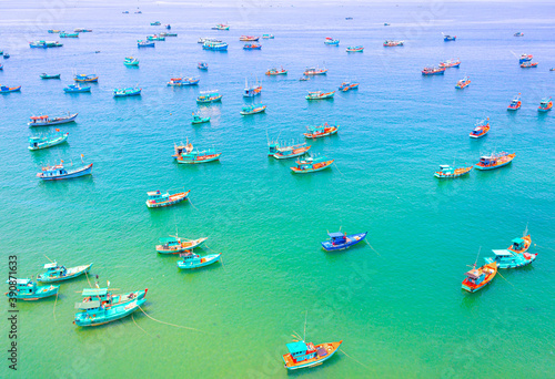 Lot of colorful wooden Vietnamese traditional fisherman boats in the azure sea. The bay is crowded with boats. Top view