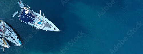 Aerial drone ultra wide photo of sail boat cruising in the deep blue Aegean sea, Greece