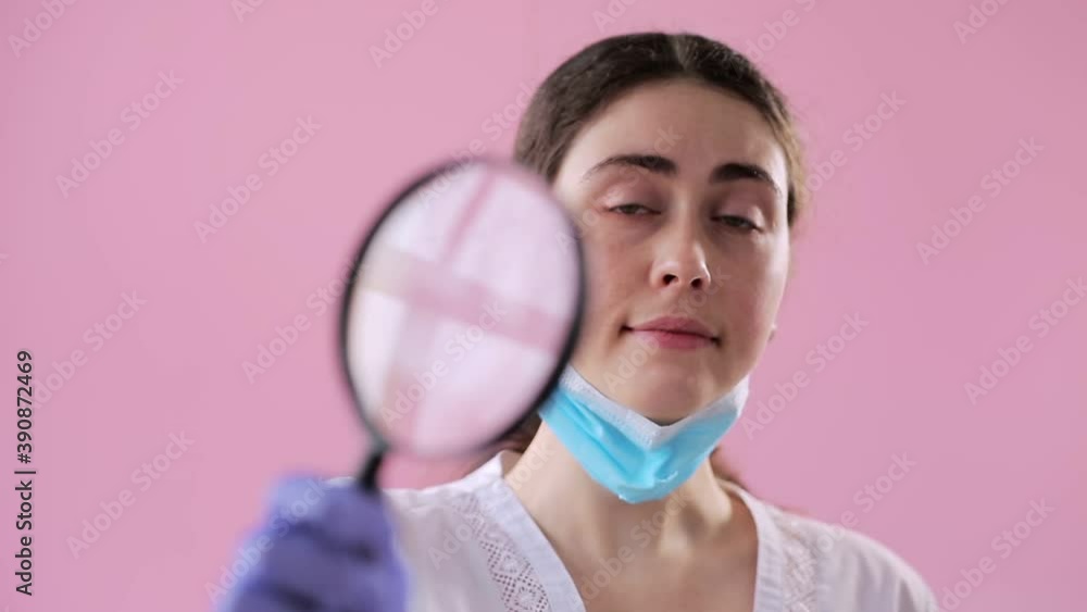 Portrait of a young female doctor wearing medical gloves and a mask who ...