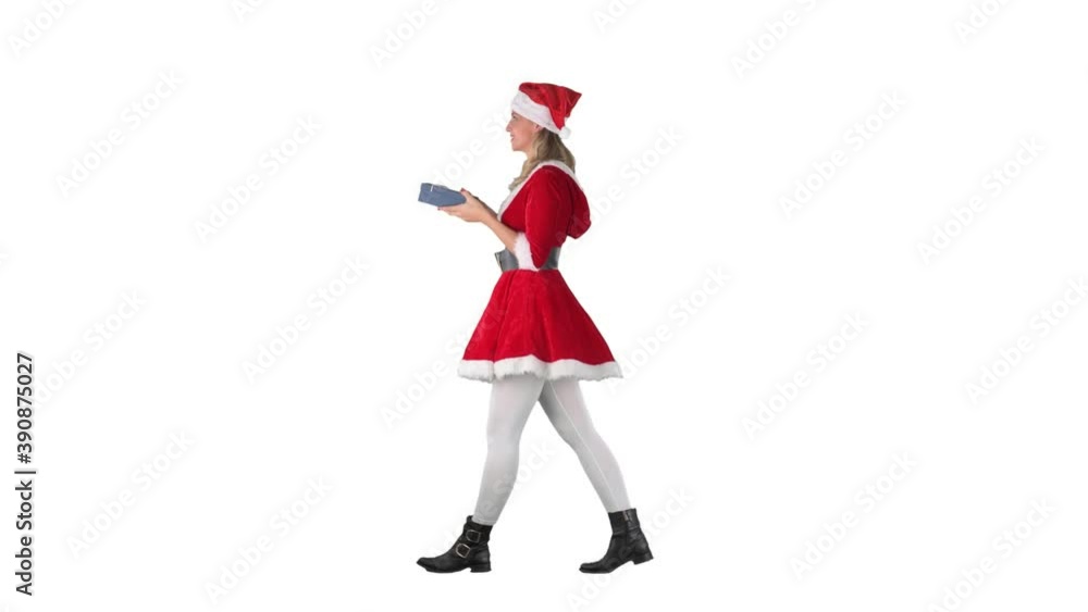 Side view of walking happy Santa girl carrying Christmas gift. Full body isolated on white background. Side view of walking happy Santa girl carrying Christmas gift. Full body isolated on white background.