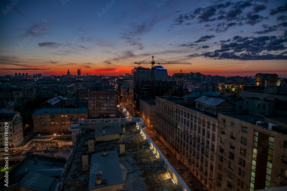 Red sunset with clouds in the city. Construction of building with crane on background. Moscow. Russia.