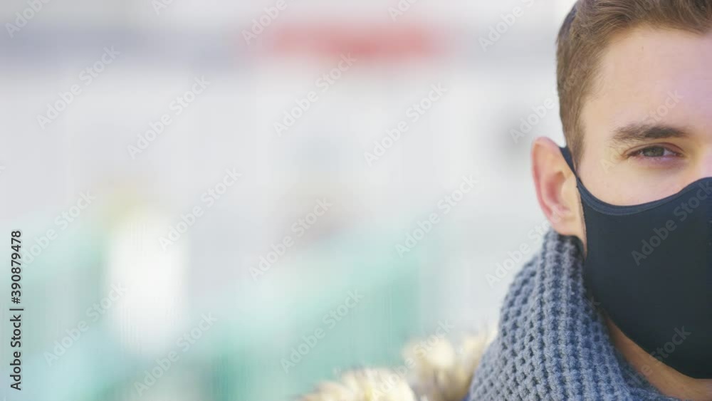 Half face portrait of young man wearing a medical mask during a pandemic and looking to camera, with space for text Half face portrait of young man wearing a medical mask during a pandemic and looking to camera, with space for text