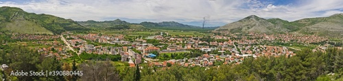 The aerial view on old Trebinje city in the lowland surrounded with mountains in summer against cloudy sky in Bosnia and Herzegovina.