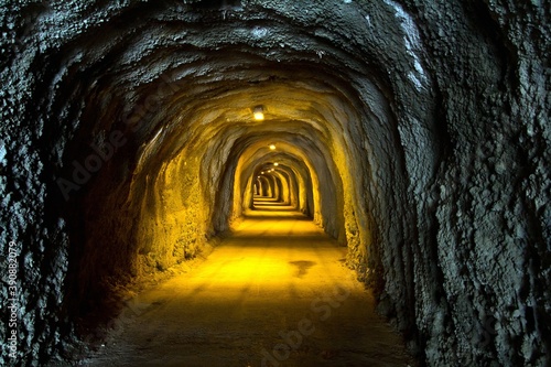 A tunnel lit up with lamps on the ceiling and a road going straight in resort Rafailovici, Montenegro.