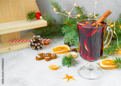  Сhristmas hot mulled wine with carnation, cinnamon, cardamom and anise on wooden background with Christmas decorations. New Year drinks.
