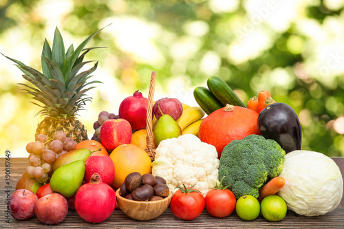 Fototapeta Naklejka Na Ścianę i Meble -  Group vegetables and Fruits Apples, grapes, oranges, and bananas in the wooden basket with carrots, tomatoes, guava, chili, eggplant, and salad on the table.Healthy food concept