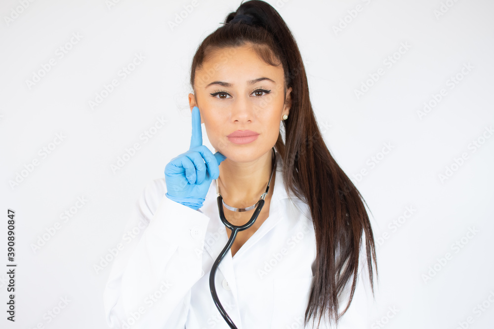 Woman in doctor uniform wearing latex gloves with thumb up over white background. Woman in doctor uniform wearing latex gloves with thumb up over white background.