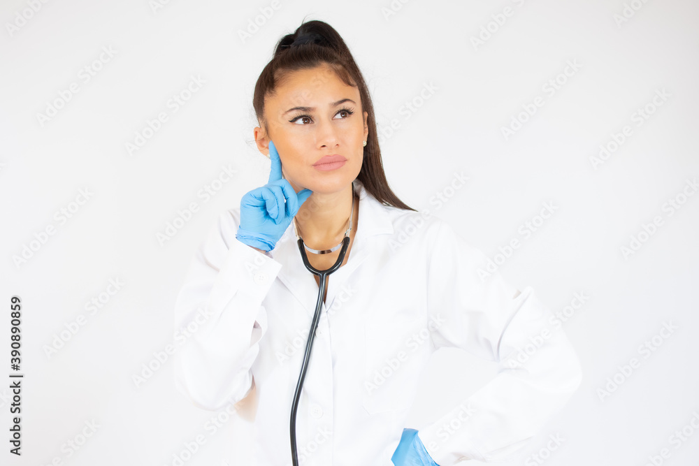 Woman in doctor uniform wearing latex gloves over white background. Woman in doctor uniform wearing latex gloves over white background.