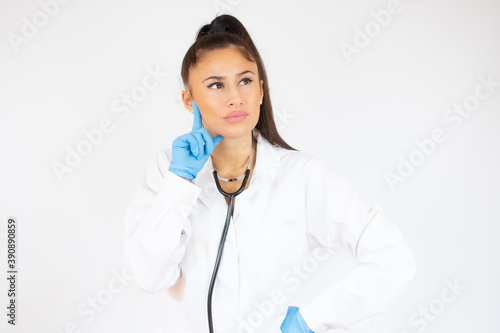 Woman in doctor uniform wearing latex gloves over white background.