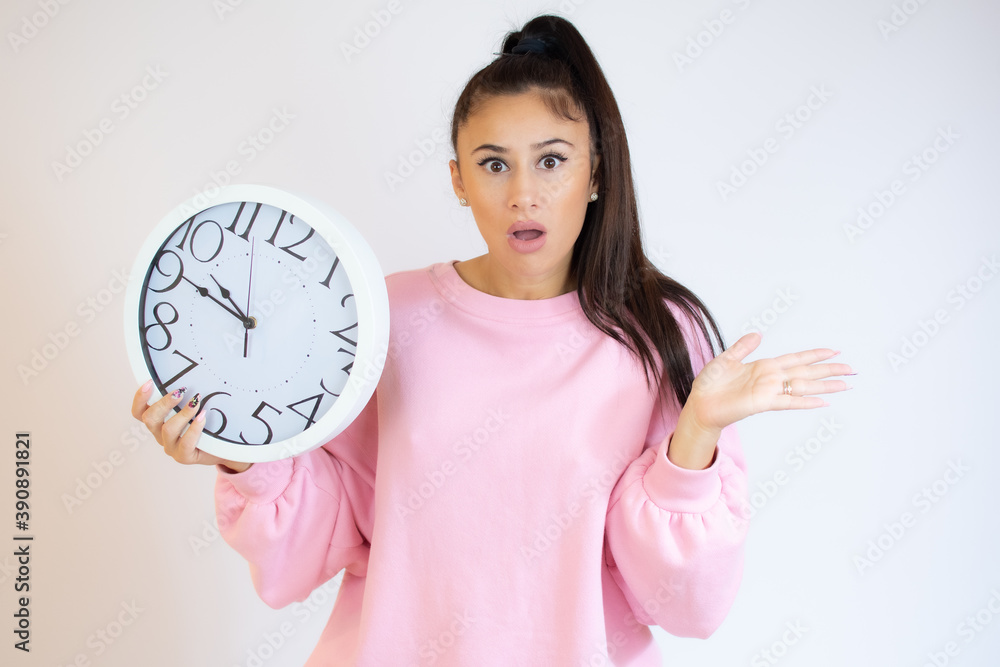 Surprised woman holding Big Clock, isolated on white background. Portrait of woman showing big clock with Stress Surprised woman holding Big Clock, isolated on white background. Portrait of woman showing big clock with Stress