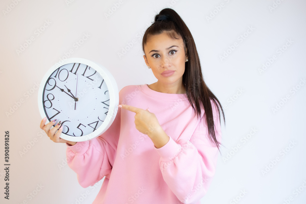 Surprised woman holding Big Clock, isolated on white background. Portrait of woman showing big clock with Stress Surprised woman holding Big Clock, isolated on white background. Portrait of woman showing big clock with Stress