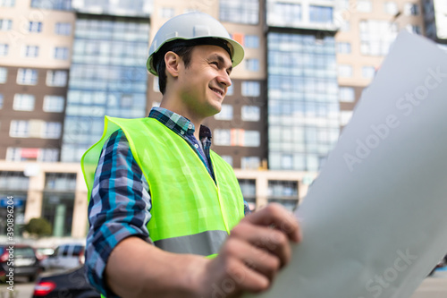 portrait of handsome young man with blueprint architect on a building industry construction site