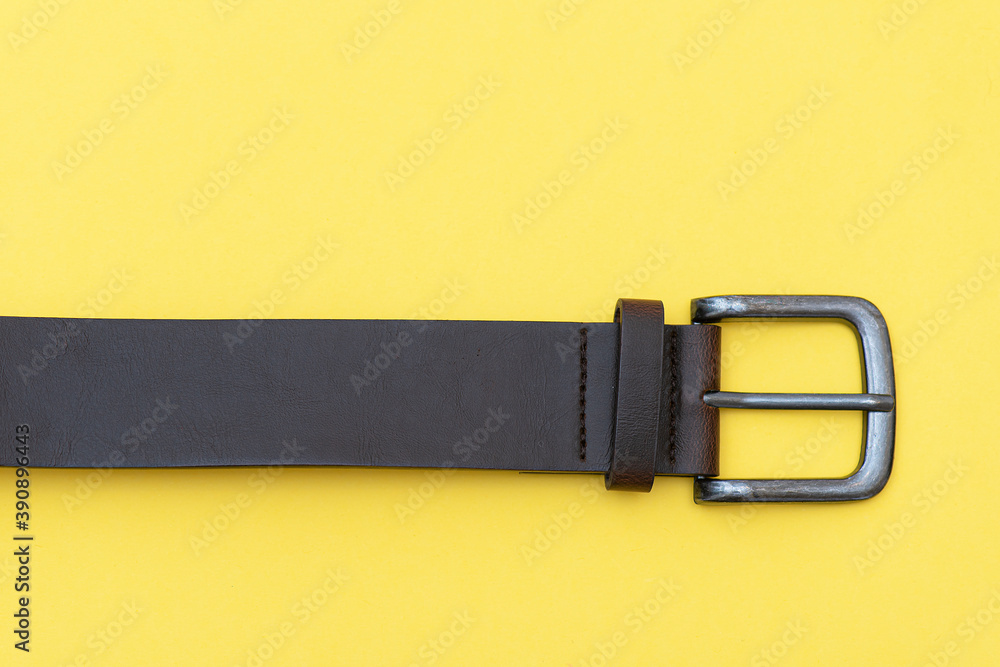 Part of leather belt on yellow background, top view. Casual style Part of leather belt on yellow background, top view. Casual style