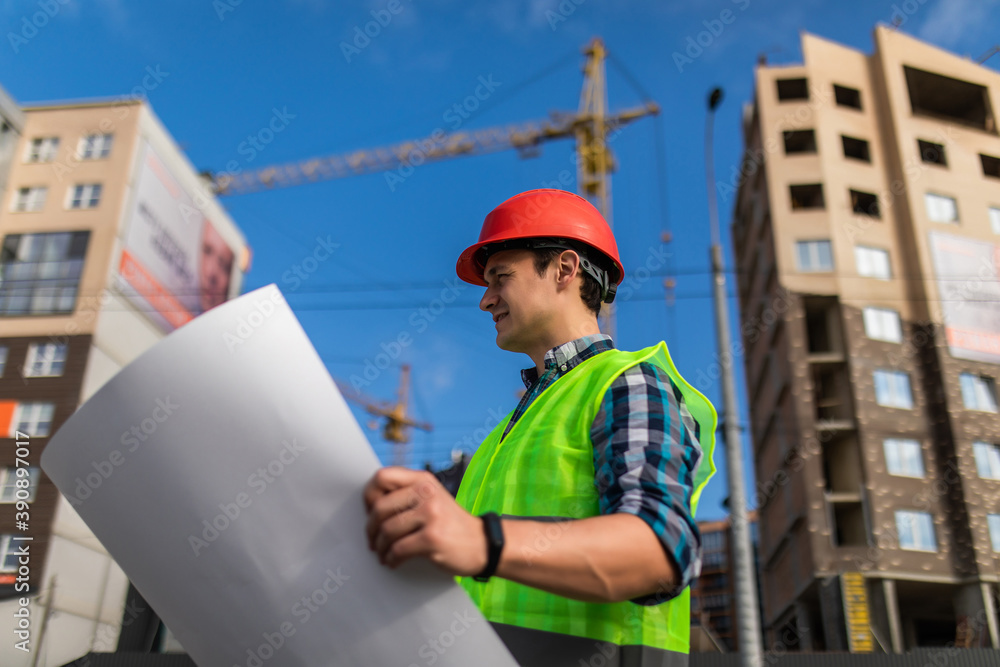portrait of handsome young man with blueprint architect on a building industry construction site portrait of handsome young man with blueprint architect on a building industry construction site