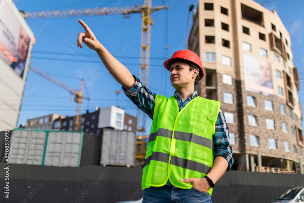 Young engineers man pointed side at the construction. Young engineers man pointed side at the construction.