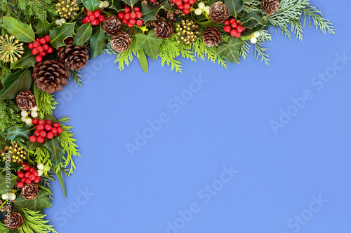 Winter, Christmas & New Year background border with holly & winter greenery. Natural & traditional flora for the festive season. Top view, flat lay, copy space.