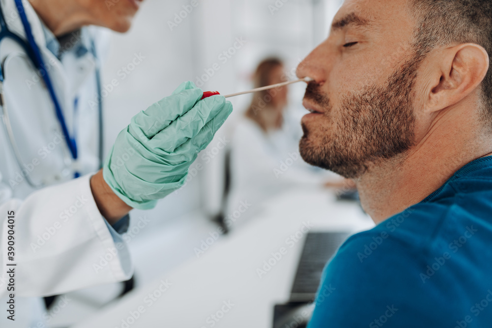 Doctor in protective gloves taking swab from her patient's nose. Doctor in protective gloves taking swab from her patient's nose.